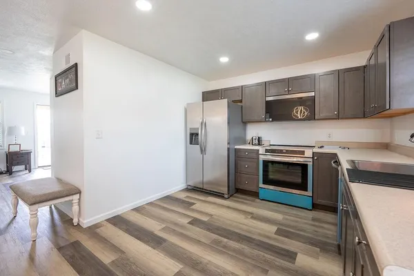 a kitchen with a table chairs a sink dishwasher and cabinets