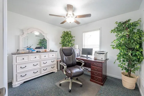 a view of a workspace with furniture and a window