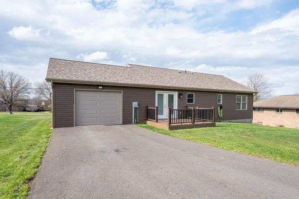 a view of a house with a yard and large tree