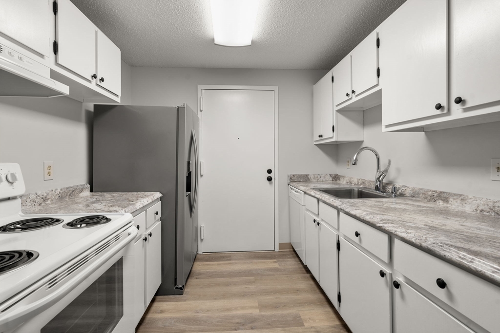 11 Silver Hill Lane, Unit 11 Natick, MA 01760 - Photo 2 of 22 a kitchen with granite countertop a sink stove and refrigerator
