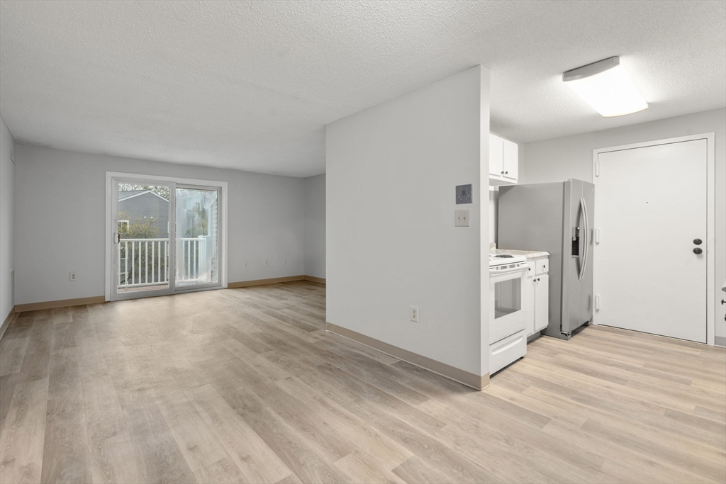 11 Silver Hill Lane, Unit 11 Natick, MA 01760 - Photo 3 of 22 a view of a kitchen with a stove cabinets and a wooden floor
