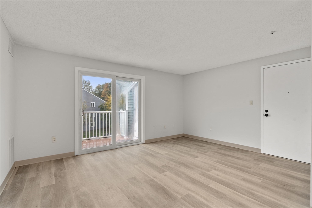 11 Silver Hill Lane, Unit 11 Natick, MA 01760 - Photo 4 of 22 a view of empty room with wooden floor and fan