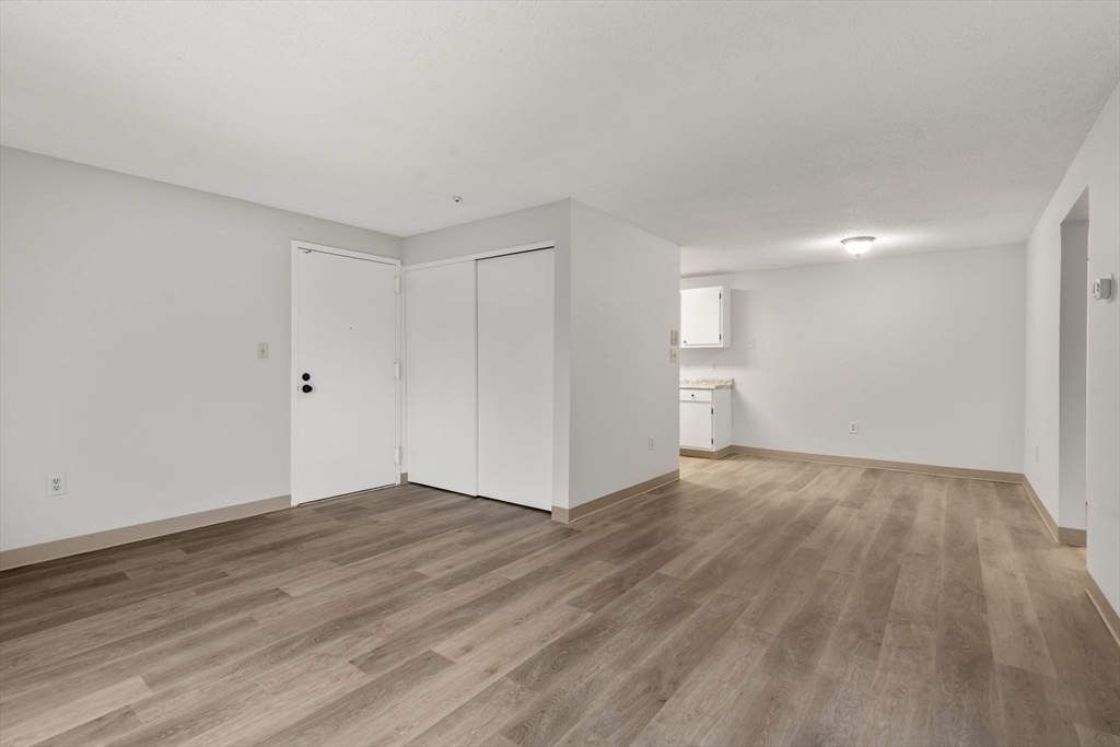 11 Silver Hill Lane, Unit 11 Natick, MA 01760 - Photo 6 of 22 a view of an empty room with wooden floor and white doors