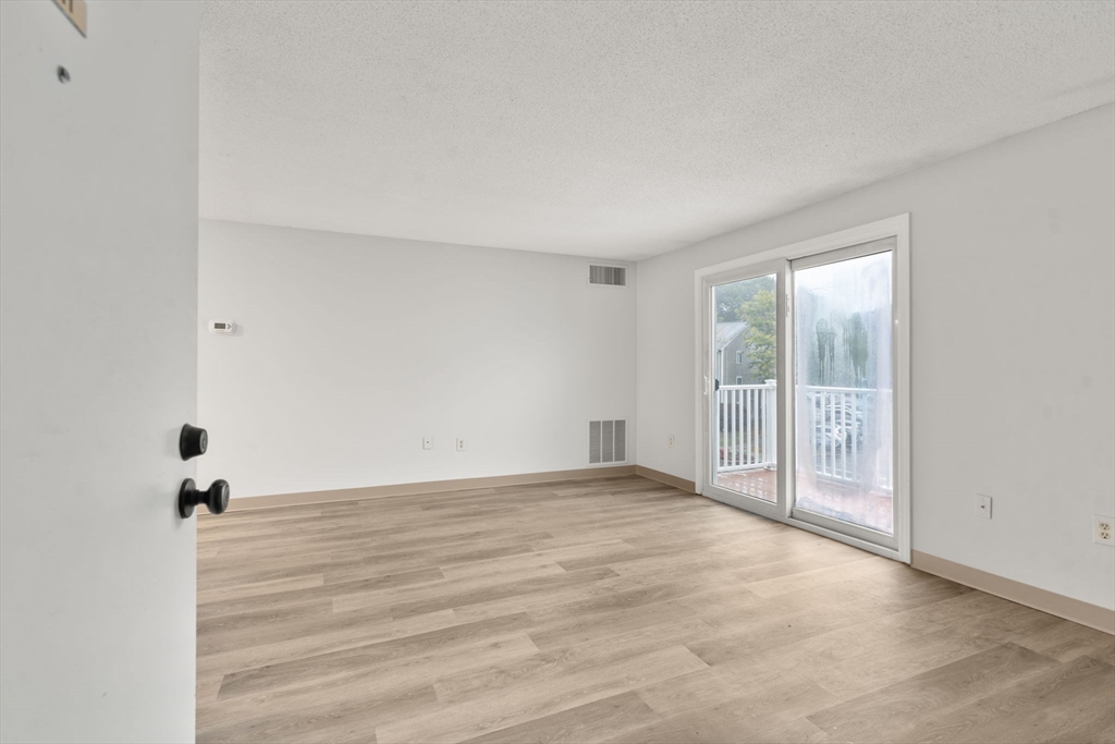 11 Silver Hill Lane, Unit 11 Natick, MA 01760 - Photo 7 of 22 a view of an empty room with wooden floor and a window