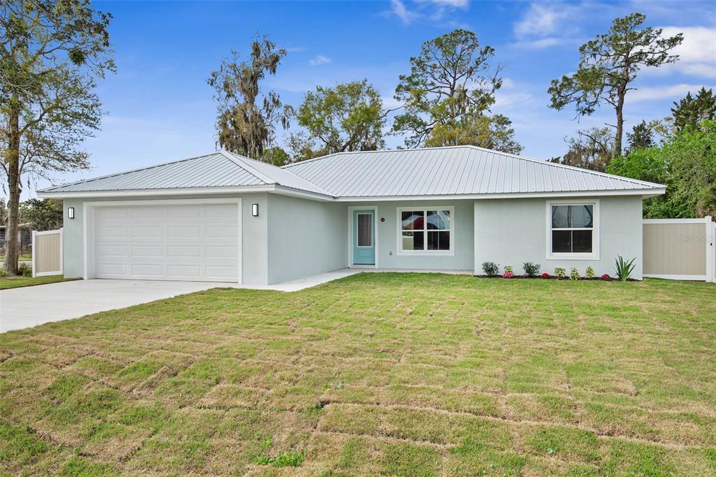 261 South Main Street Bunnell, FL 32110 - Photo 1 of 56 a yellow house with a garden