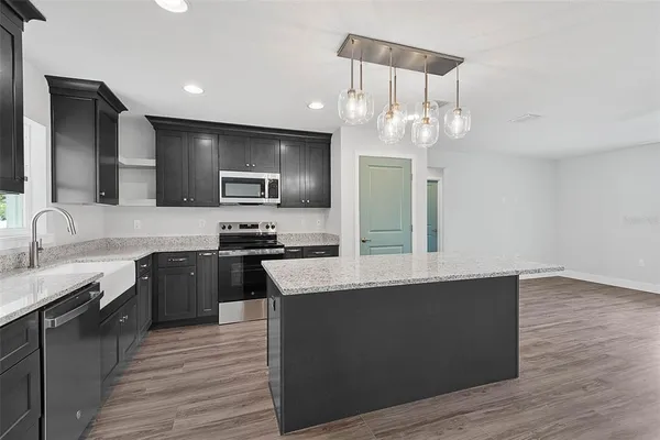a kitchen with a sink a stove and microwave
