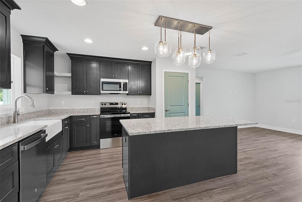 261 South Main Street Bunnell, FL 32110 - Photo 13 of 56 a large kitchen with granite countertop a large counter top appliances and cabinets