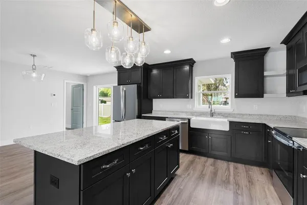 a view of a kitchen with stainless steel appliances a refrigerator and wooden floor