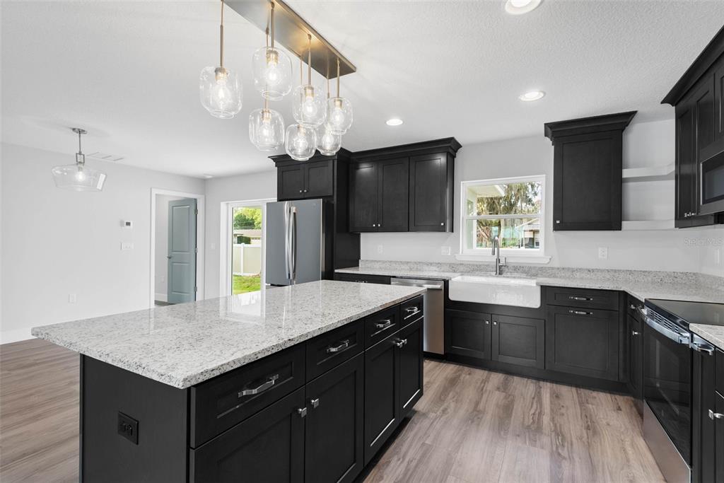 261 South Main Street Bunnell, FL 32110 - Photo 19 of 56 a kitchen with a center island appliances and cabinets