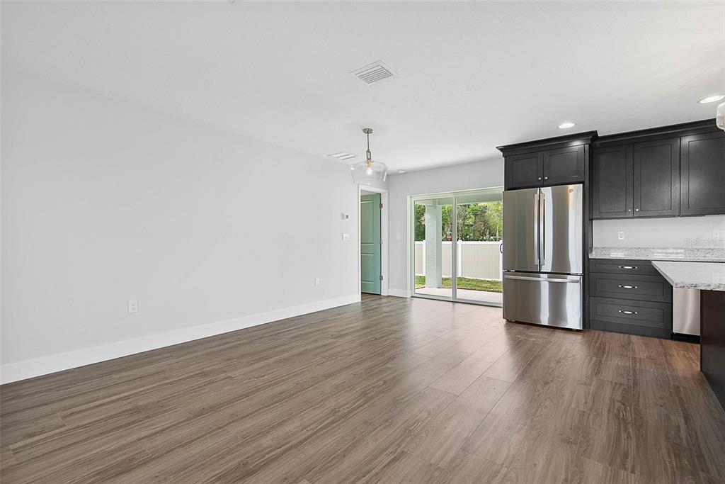 261 South Main Street Bunnell, FL 32110 - Photo 20 of 56 a view of a kitchen with stainless steel appliances a refrigerator and wooden floor