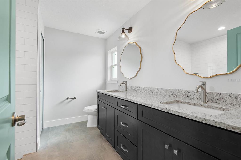 261 South Main Street Bunnell, FL 32110 - Photo 24 of 56 a bathroom with a double vanity sink and a mirror