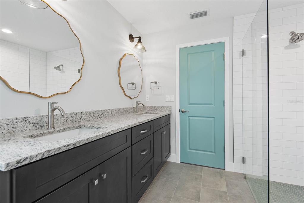 261 South Main Street Bunnell, FL 32110 - Photo 26 of 56 a bathroom with a granite countertop sink mirror and vanity