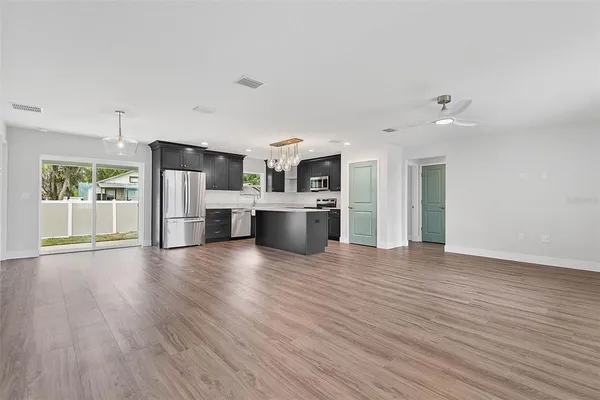 a view of kitchen with granite countertop stainless steel appliances cabinets and a wooden floor