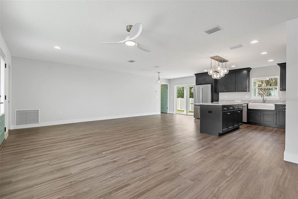 261 South Main Street Bunnell, FL 32110 - Photo 9 of 56 a large kitchen with stainless steel appliances a large counter top a fireplace and a wooden floor