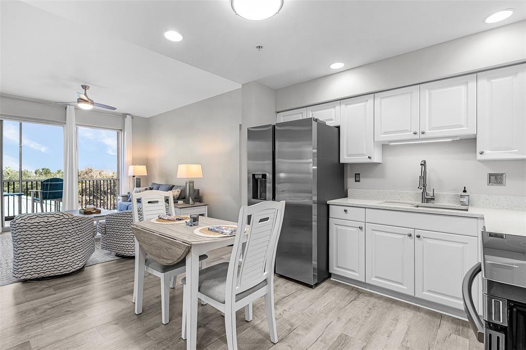 2060 Matecumbe Key Road, Unit 2307 Punta Gorda, FL 33955 - Photo 2 of 45 a kitchen with stainless steel appliances kitchen island granite countertop a dining table chairs and a refrigerator
