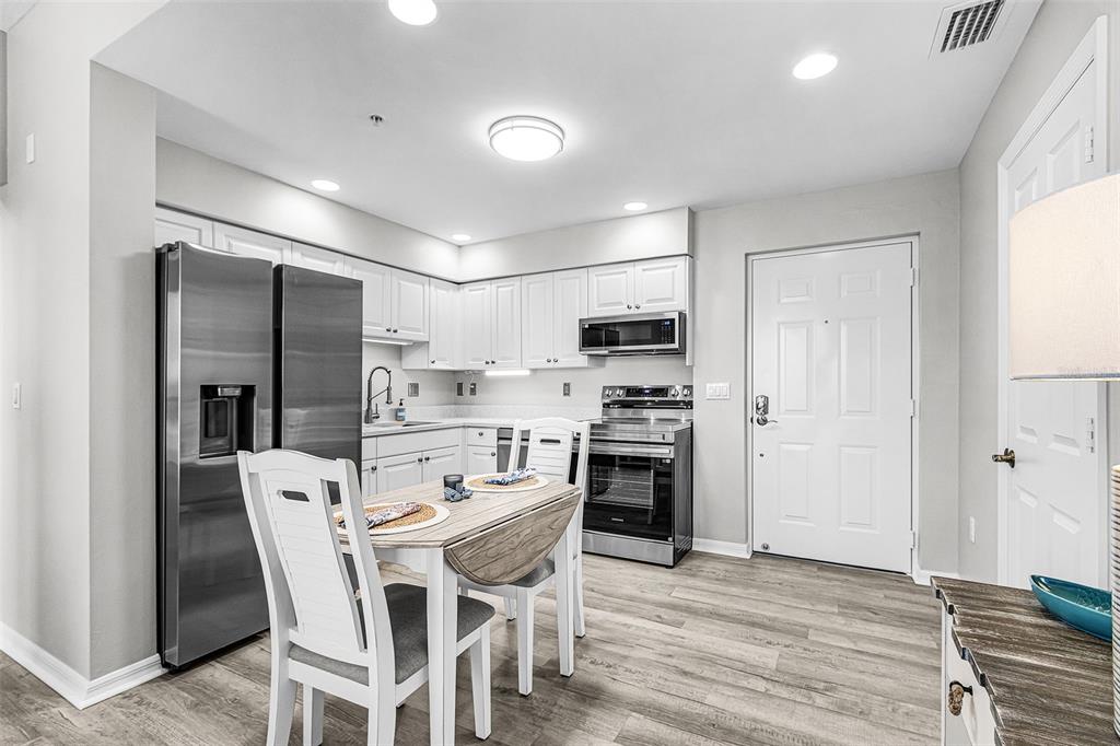 2060 Matecumbe Key Road, Unit 2307 Punta Gorda, FL 33955 - Photo 4 of 45 a kitchen with stainless steel appliances a dining table chairs refrigerator and cabinets
