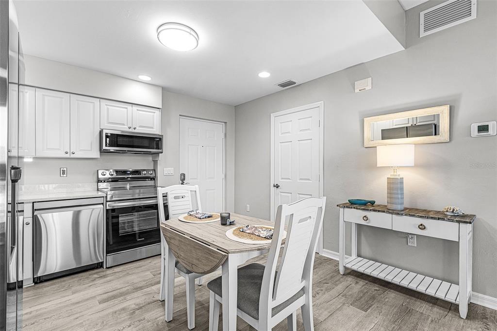 2060 Matecumbe Key Road, Unit 2307 Punta Gorda, FL 33955 - Photo 5 of 45 a kitchen with stainless steel appliances kitchen island granite countertop a stove top oven a sink dishwasher a dining table and chairs