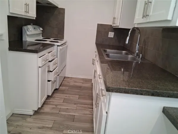 a kitchen with granite countertop a stove and a refrigerator