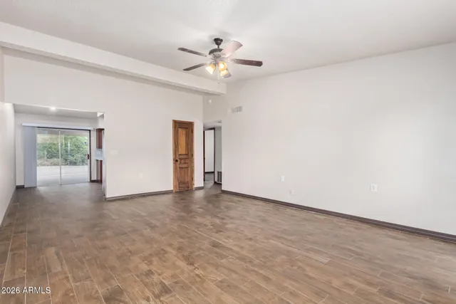 an empty room with fan and windows