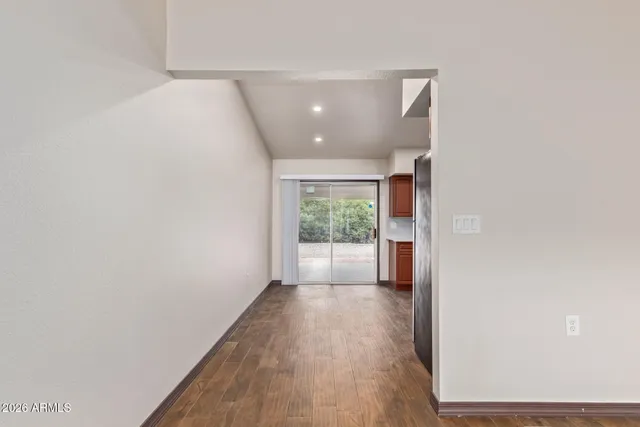 a view of a hallway with wooden floor and entryway