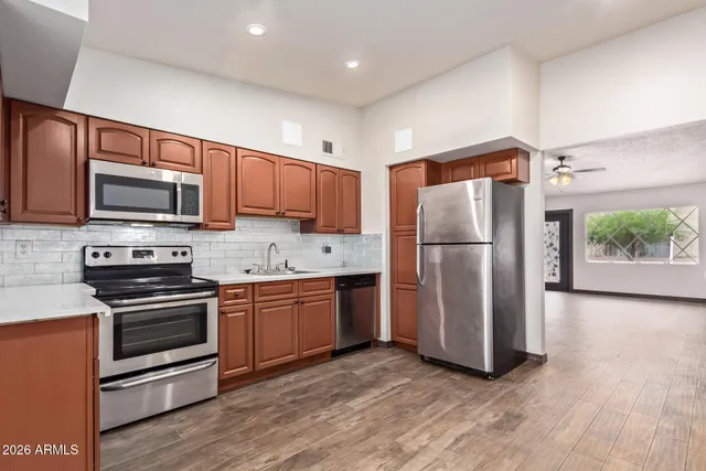 a kitchen with stainless steel appliances granite countertop a refrigerator microwave and stove top oven