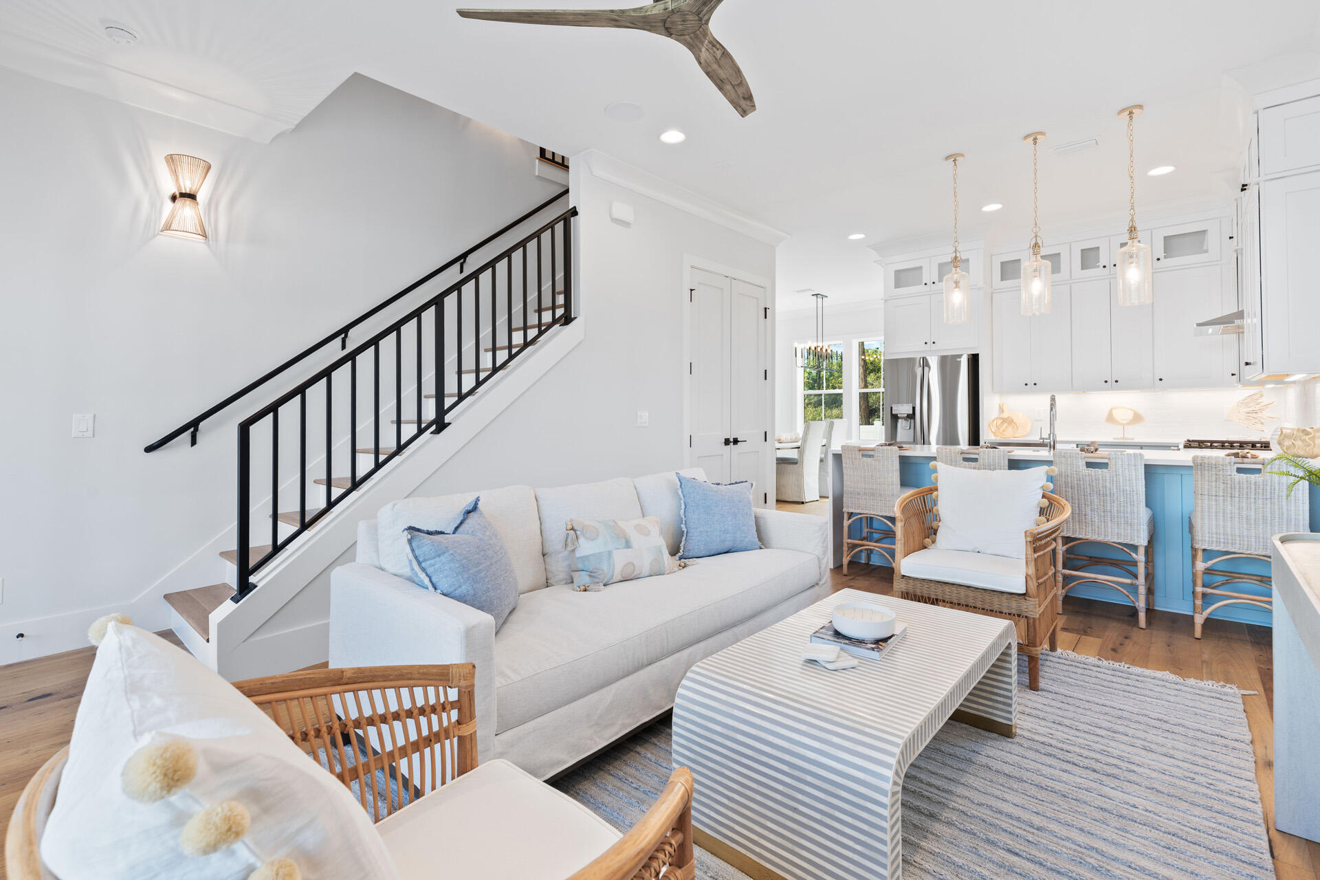 a living room with furniture kitchen view and a wooden floor
