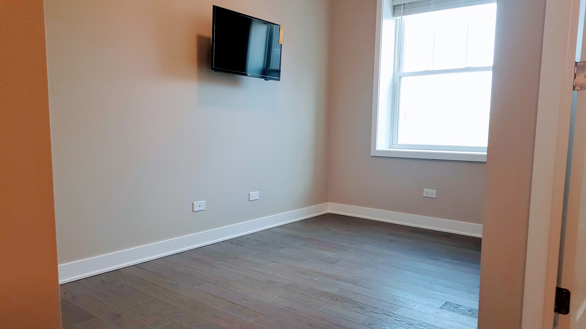 1409 West Diversey Parkway, Unit 320 Chicago, IL 60614 - Photo 10 of 13 an empty room with wooden floor and windows