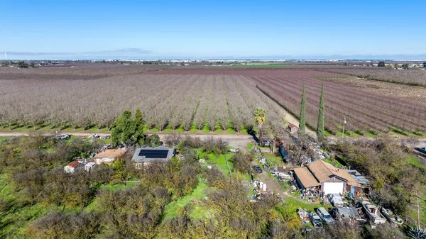 an aerial view of a residential houses with outdoor space and lake view