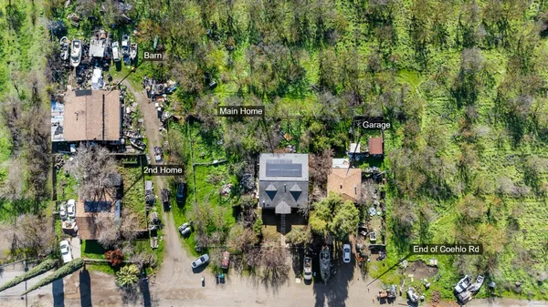 an aerial view of a residential apartment building with a yard and large trees