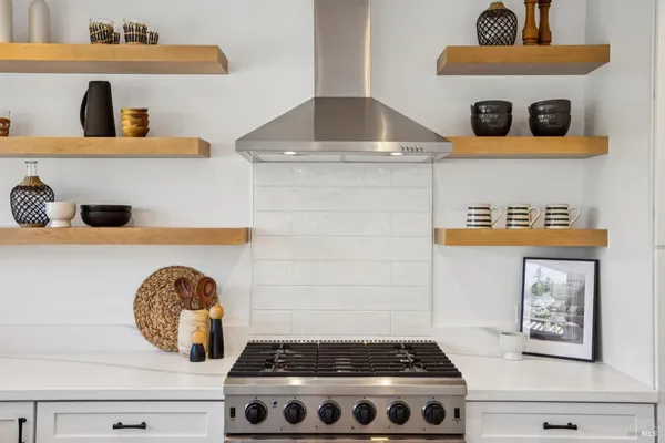 a kitchen with granite countertop a sink stove and cabinets