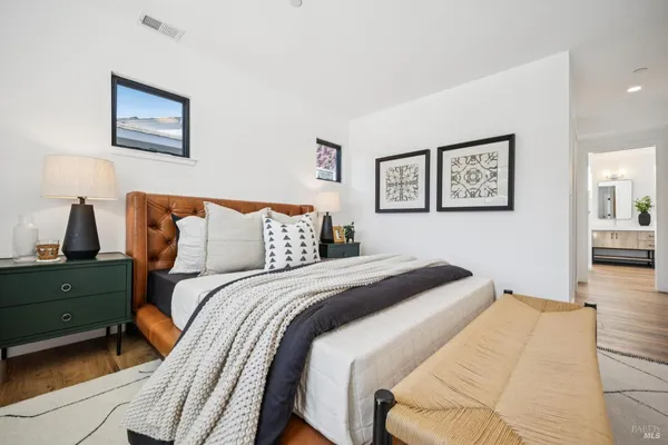 a bed room with a bed and a painting on the wall