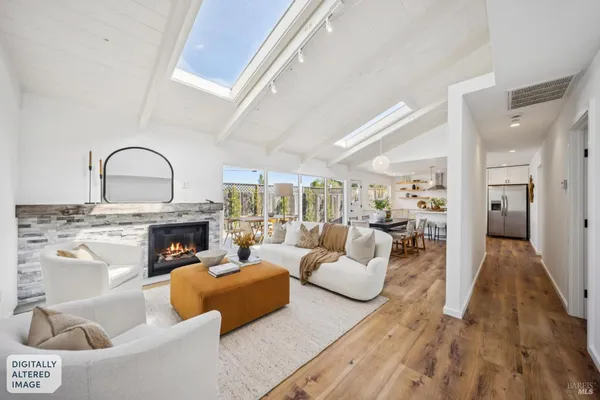 a living room with furniture a fireplace and a large window