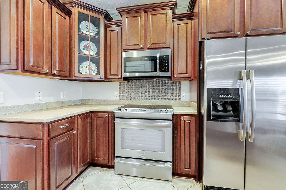 110 Cobbleton Drive Rincon, GA 31326 - Photo 17 of 41 a kitchen with stainless steel appliances wooden cabinets and a stove top oven