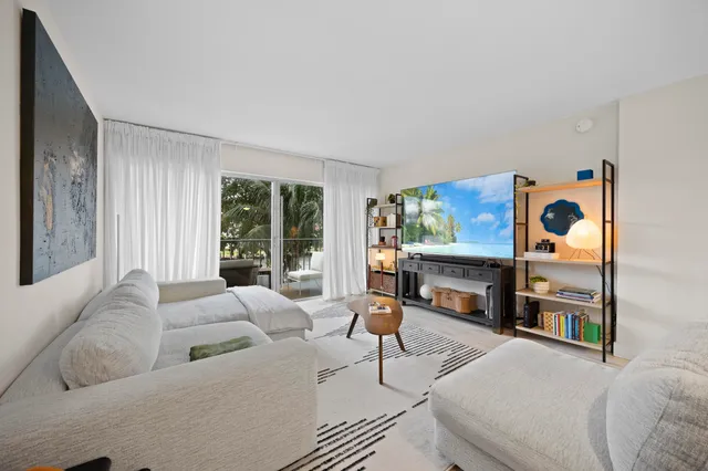 a living room with furniture a flat screen tv and a large window