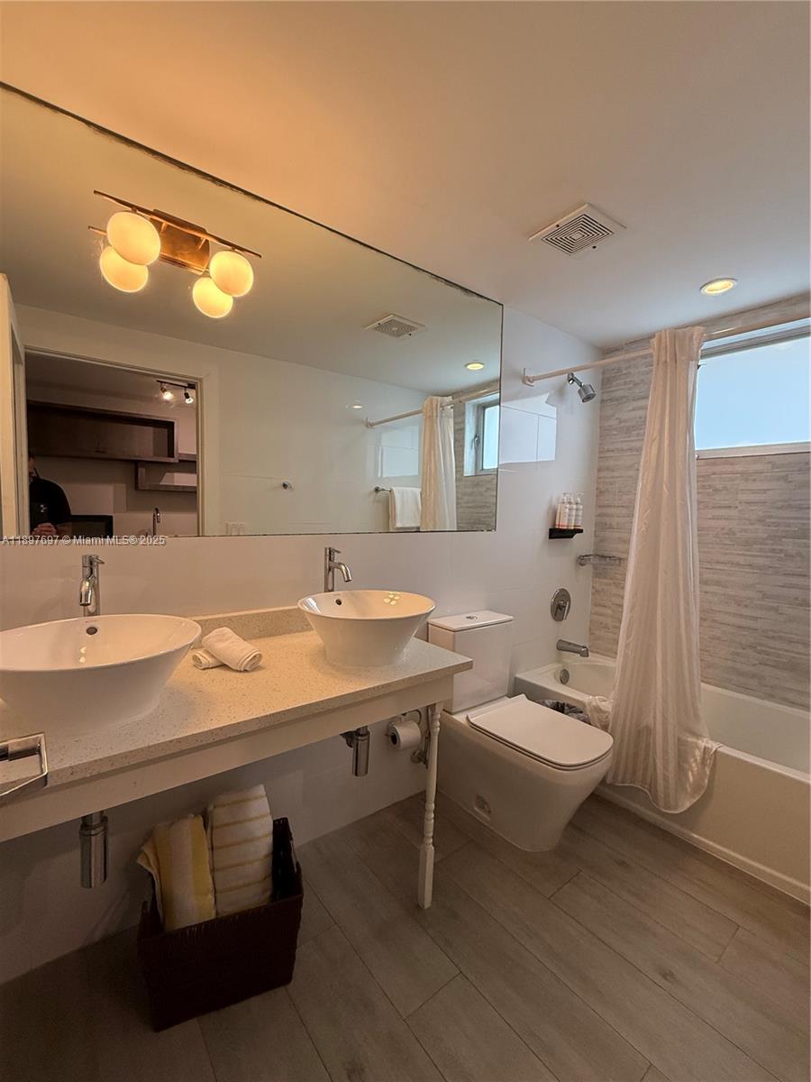 6755 Harding Avenue, Unit 2 Miami Beach, FL 33141 - Photo 4 of 10 a bathroom with a sink a toilet and shower