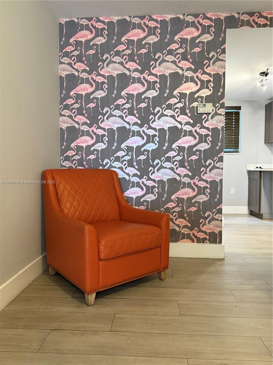 6755 Harding Avenue, Unit 2 Miami Beach, FL 33141 - Photo 7 of 10 a blue couch sitting in a living room with a rug