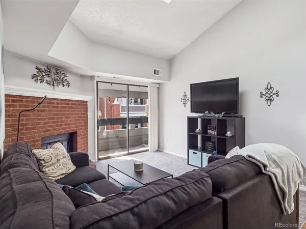 a living room with furniture a flat screen tv and a floor to ceiling window