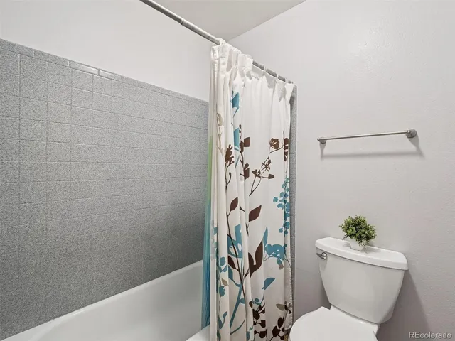 a white toilet sitting next to a shower curtain