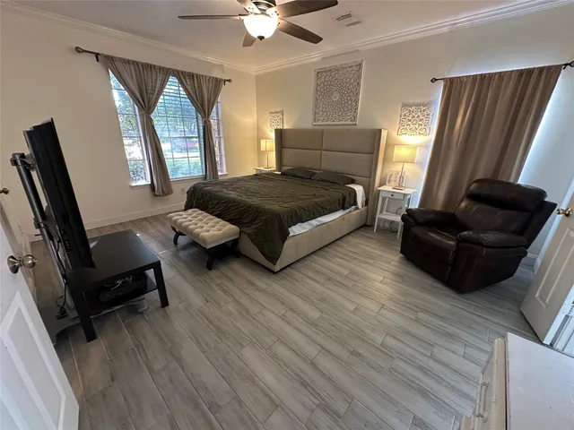 a bedroom with a bed wooden floor and window