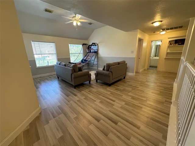 a living room with furniture and a wooden floor