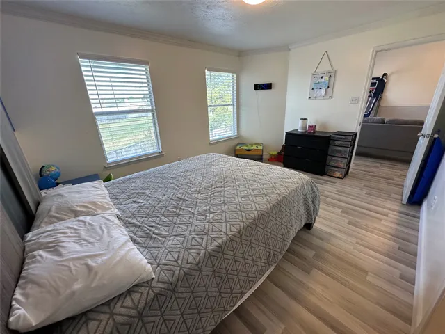 a bed sitting in a bedroom next to a window with tv