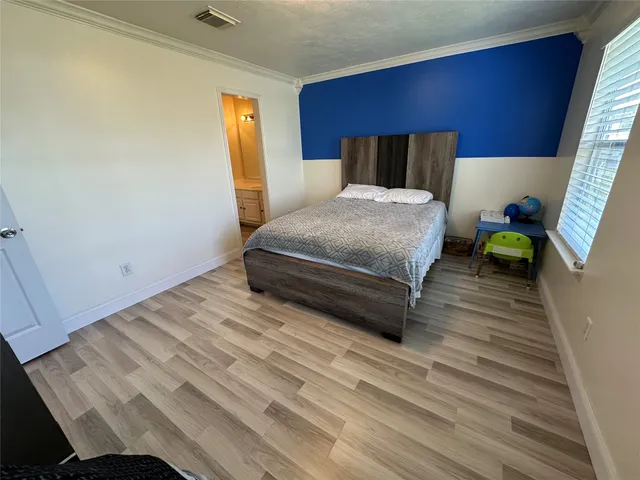 a bedroom with a bed and wooden floor