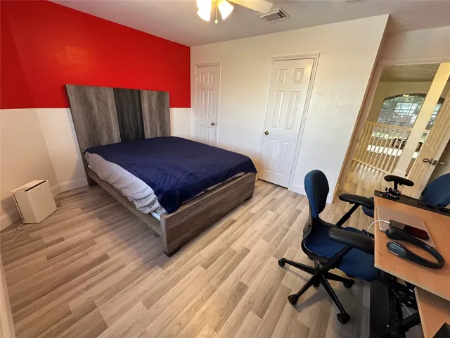 a bedroom with a bed and wooden floor