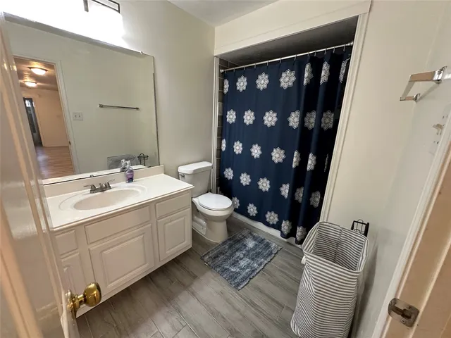 a bathroom with a granite countertop sink toilet and shower