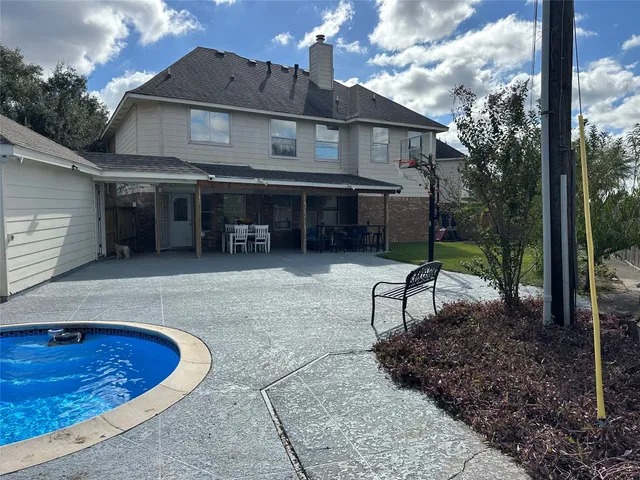 a view of a house with a patio and a yard