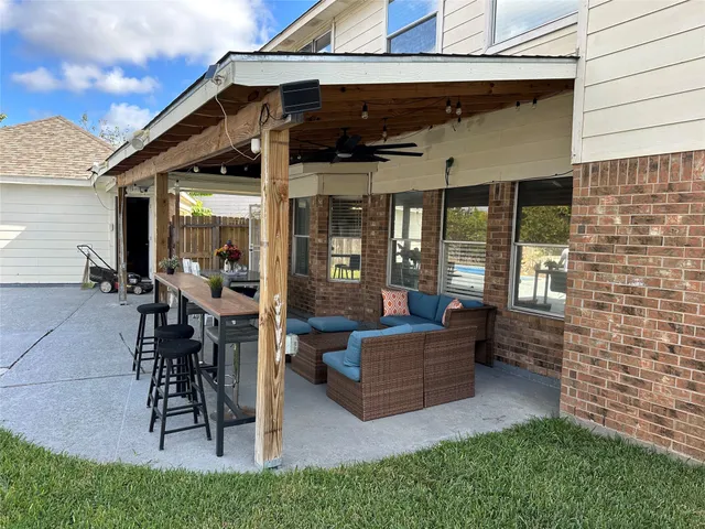 a view of swimming pool with outdoor seating and house in the background