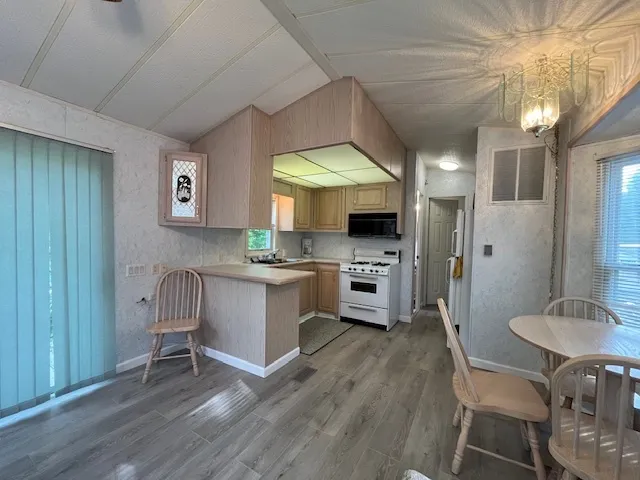 a kitchen with a table chairs refrigerator and cabinets