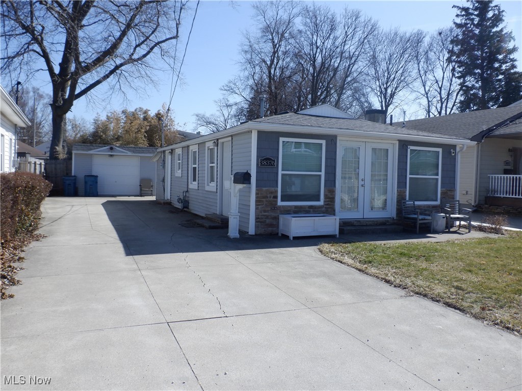 38376 Beachview Road Willoughby, OH 44094 - Photo 1 of 10 View of front of property with french doors, stone siding, an outdoor structure, and driveway