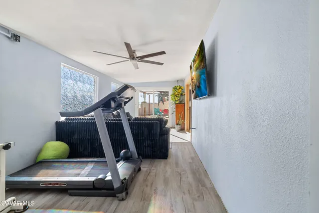 a room with gym equipment and wooden floor