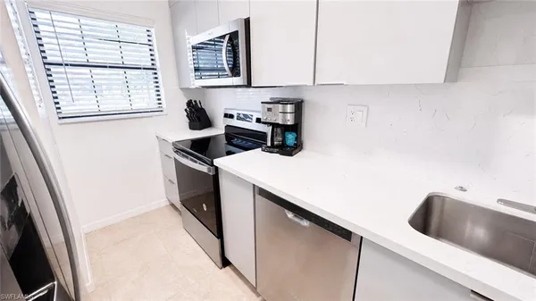 a kitchen with a cabinets and white appliances